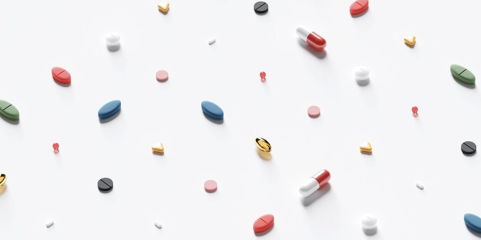 white background with constellation of rainbow colored pills in different shapes and sizes