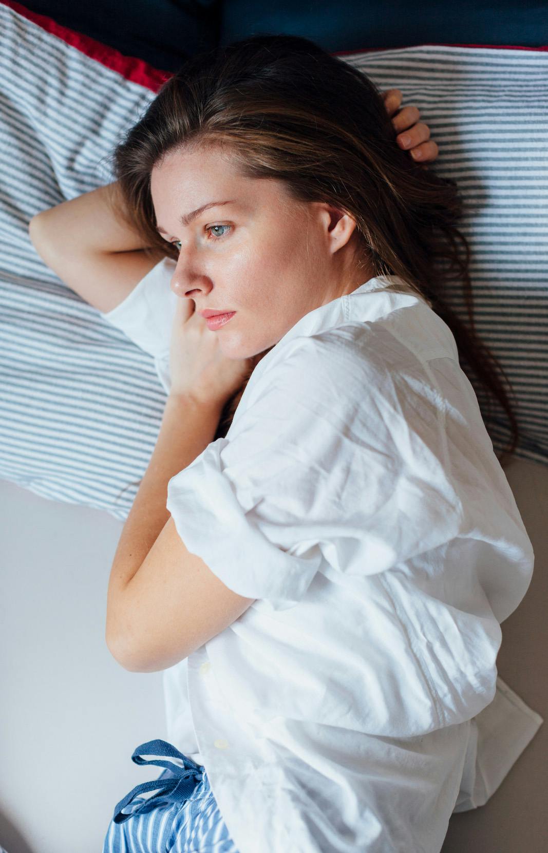 Woman laying in bed with the flu, incapable of doing anything